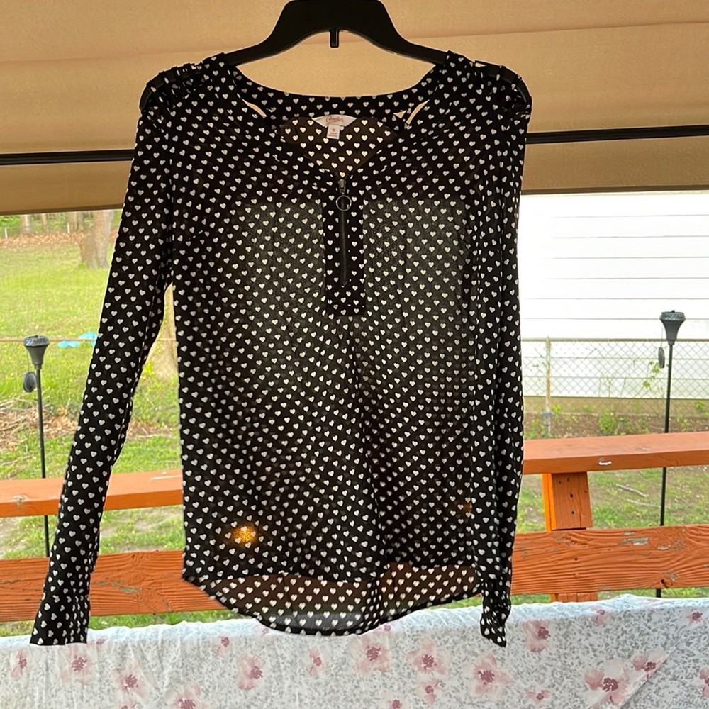 Long sleeve black blouse w/white heart print. cutouts on shoulders. Zip up front